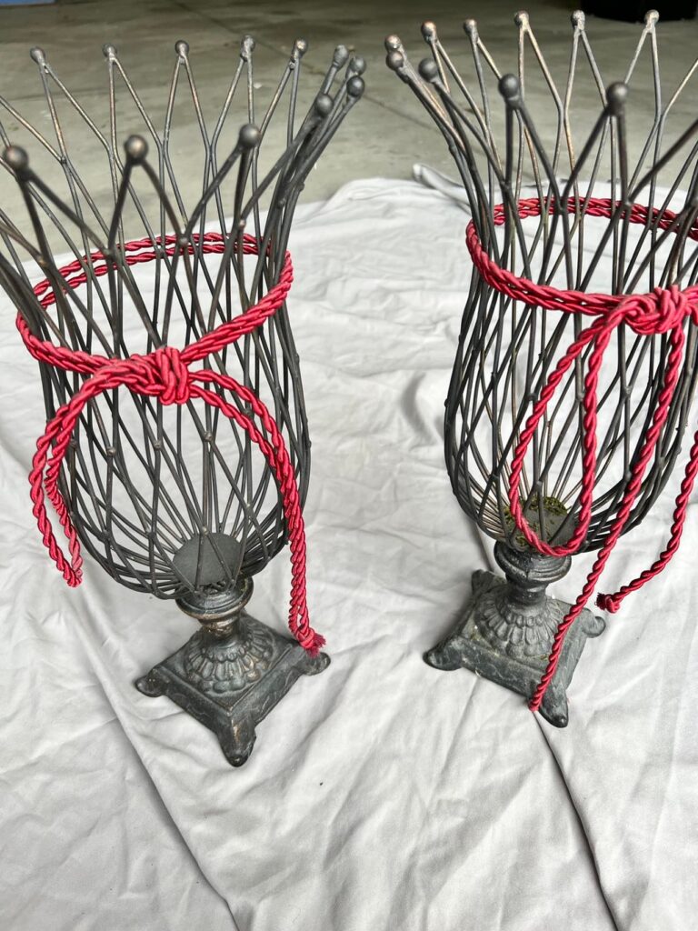 Two matching woven vases with red rope tied around the center.