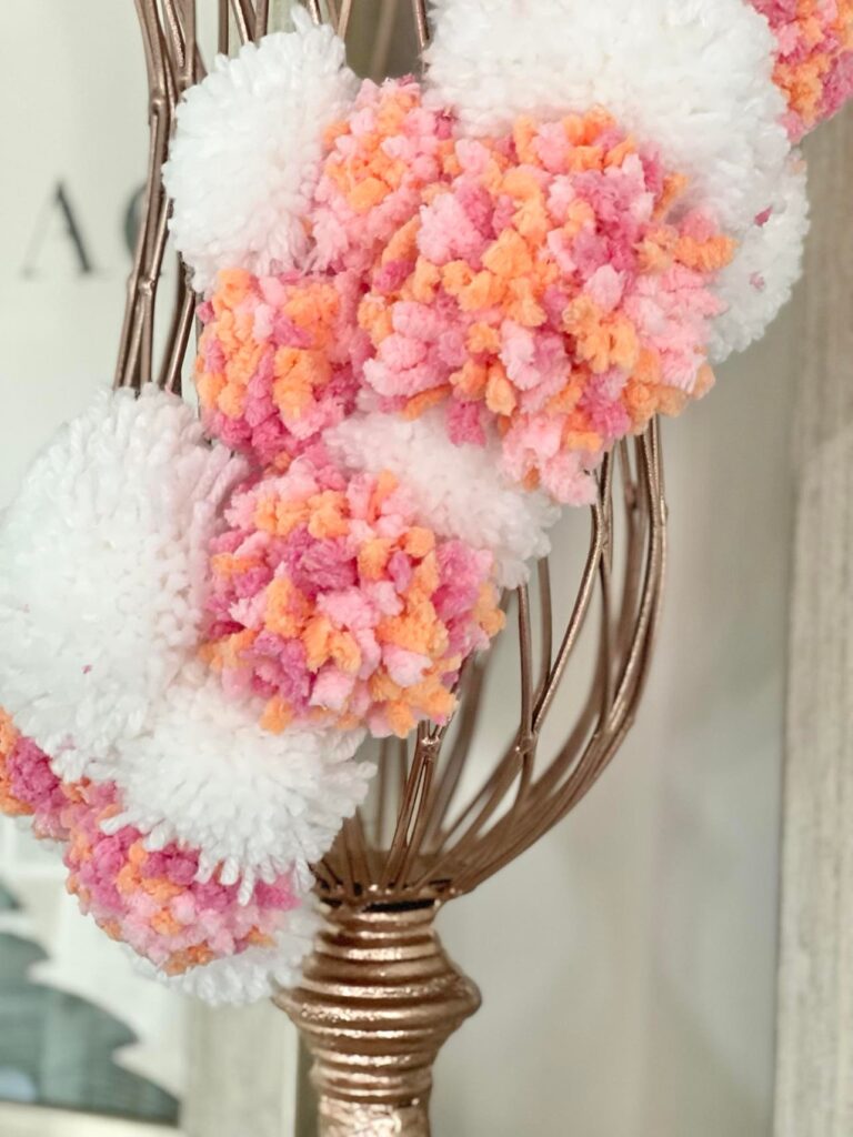 The second trash to treasure vase with white and multi-colored pom-poms attached in a serpentine pattern.