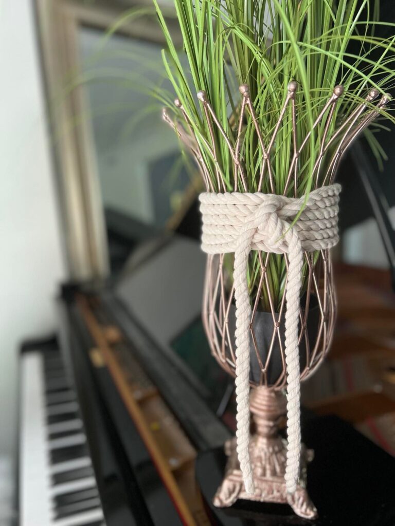 Faux grasses added to the copper vase with white cotton roping.