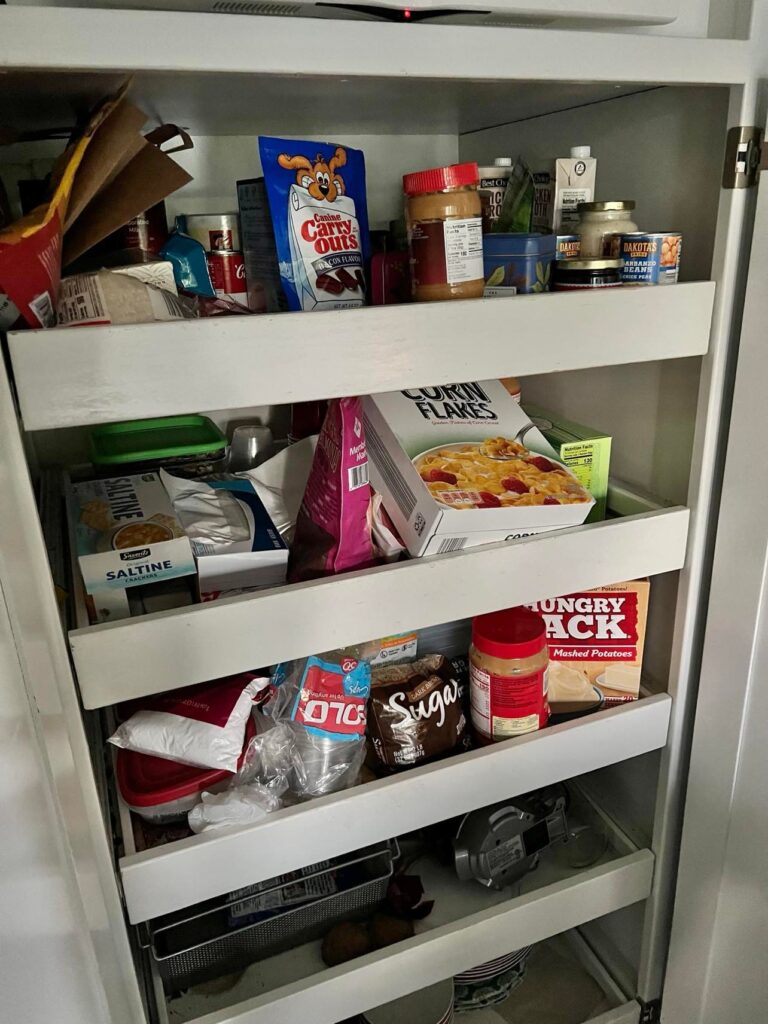 Pantry drawers filled with food items in a very disorganized fashion. Need to organize this pantry with roll out drawers.