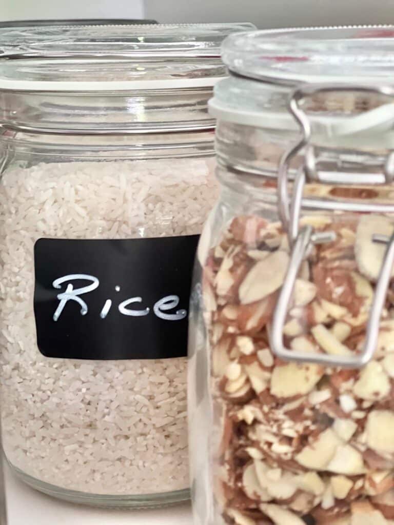 Two labeled jars containing rice and almonds.