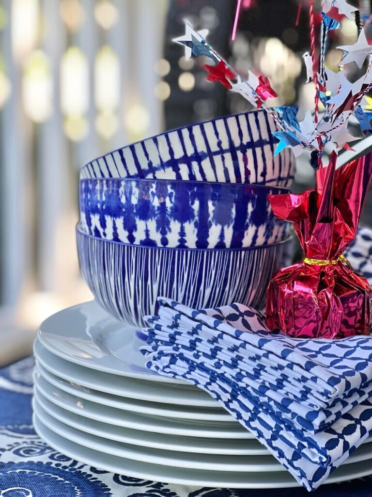 Blue and white bowls and napkins on top of white plates.