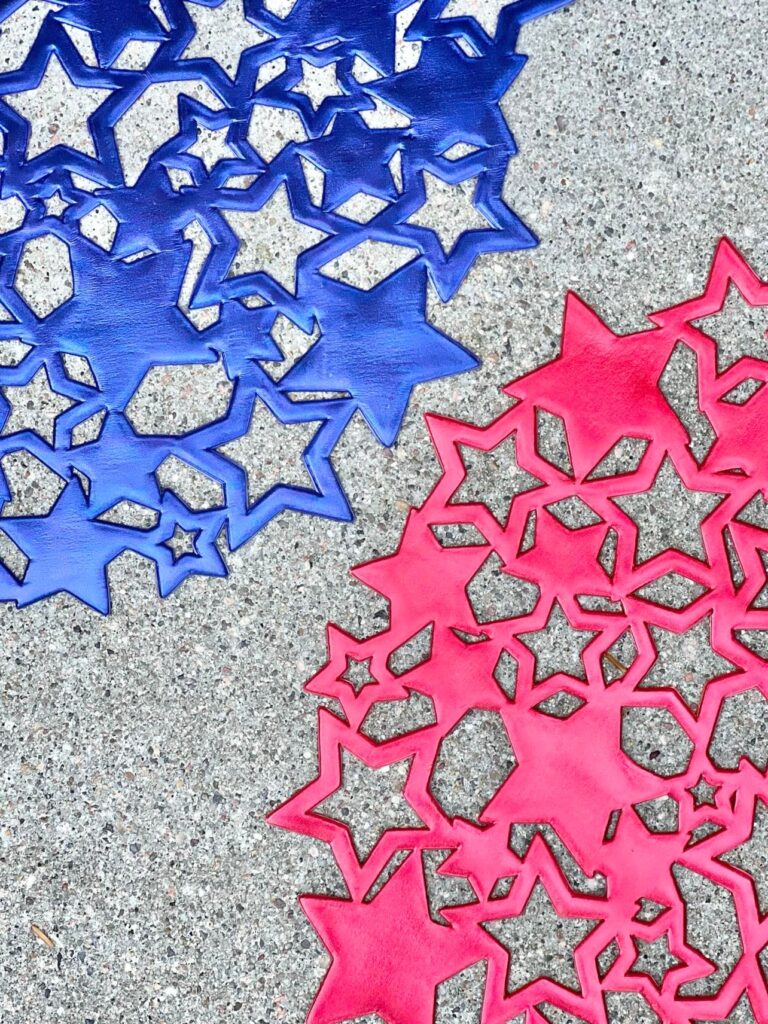 Red and blue vinyl cutout star placemats sitting on the concrete walkway.