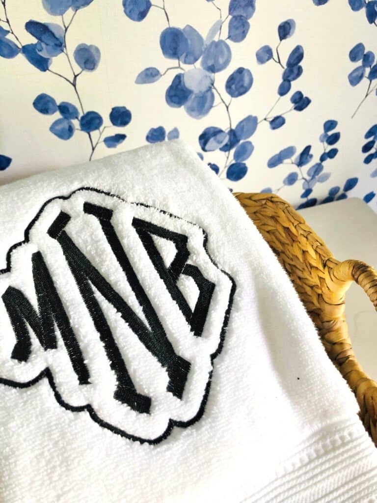 A budget-friendly bathroom spa experience starts with fluffy white bath towels. These white towels are monogrammed with the initials MNB.