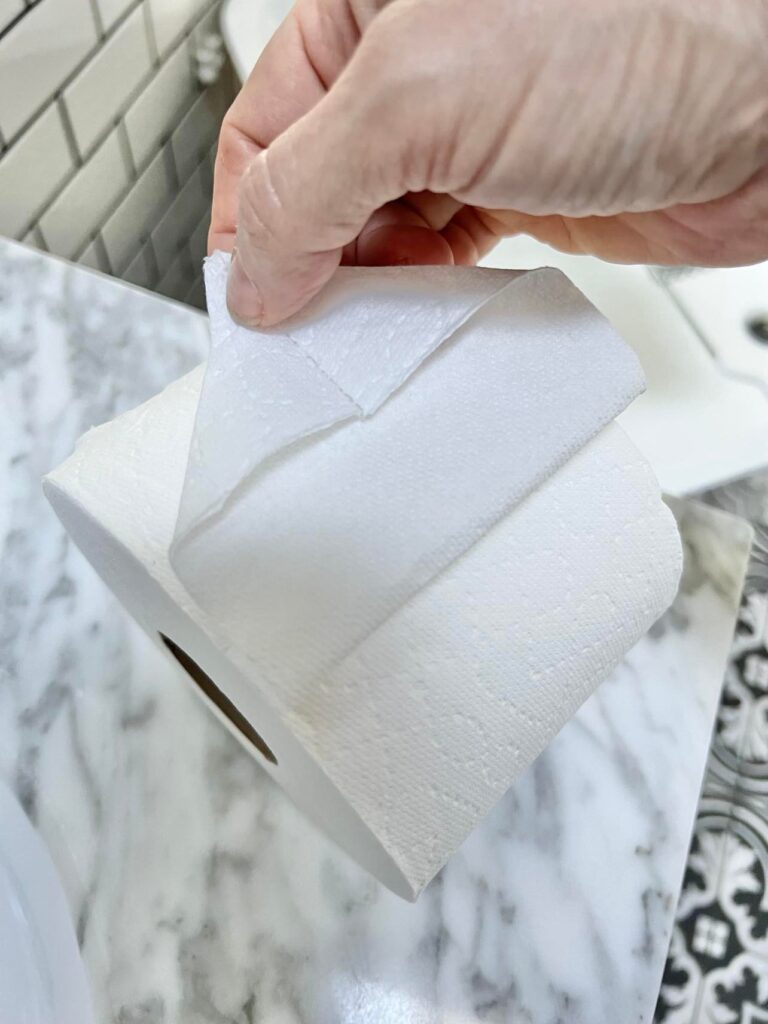 Folding the end square of a roll of toilet tissue.
