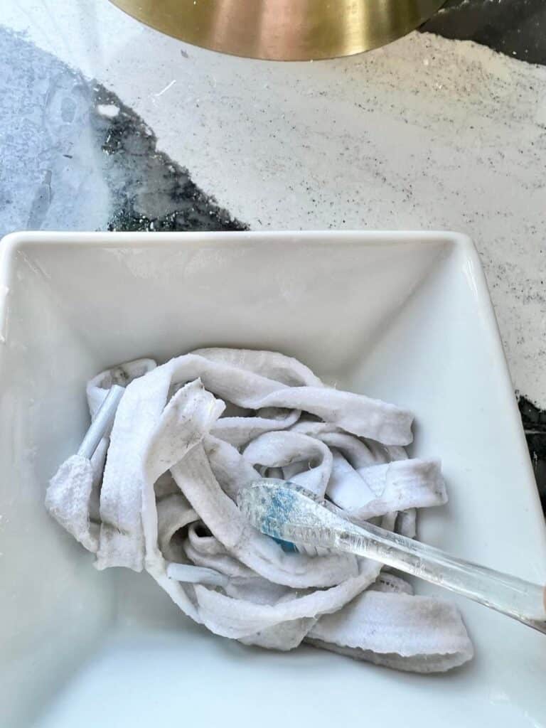 Applying the same paste with a toothbrush to the shoelaces.