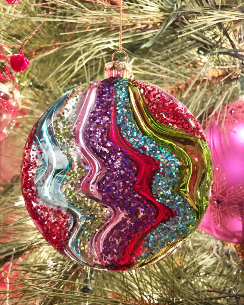 A glittery ornaments in the colors of pink, purple, red, blue and green.