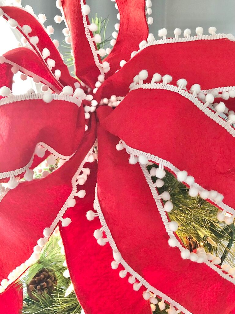 A red bow with white pom poms.