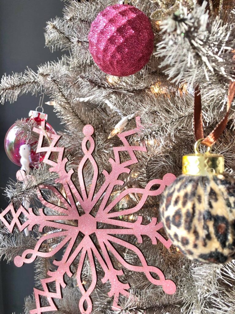 Pink and animal print ornaments on a champagne gold Christmas tree.