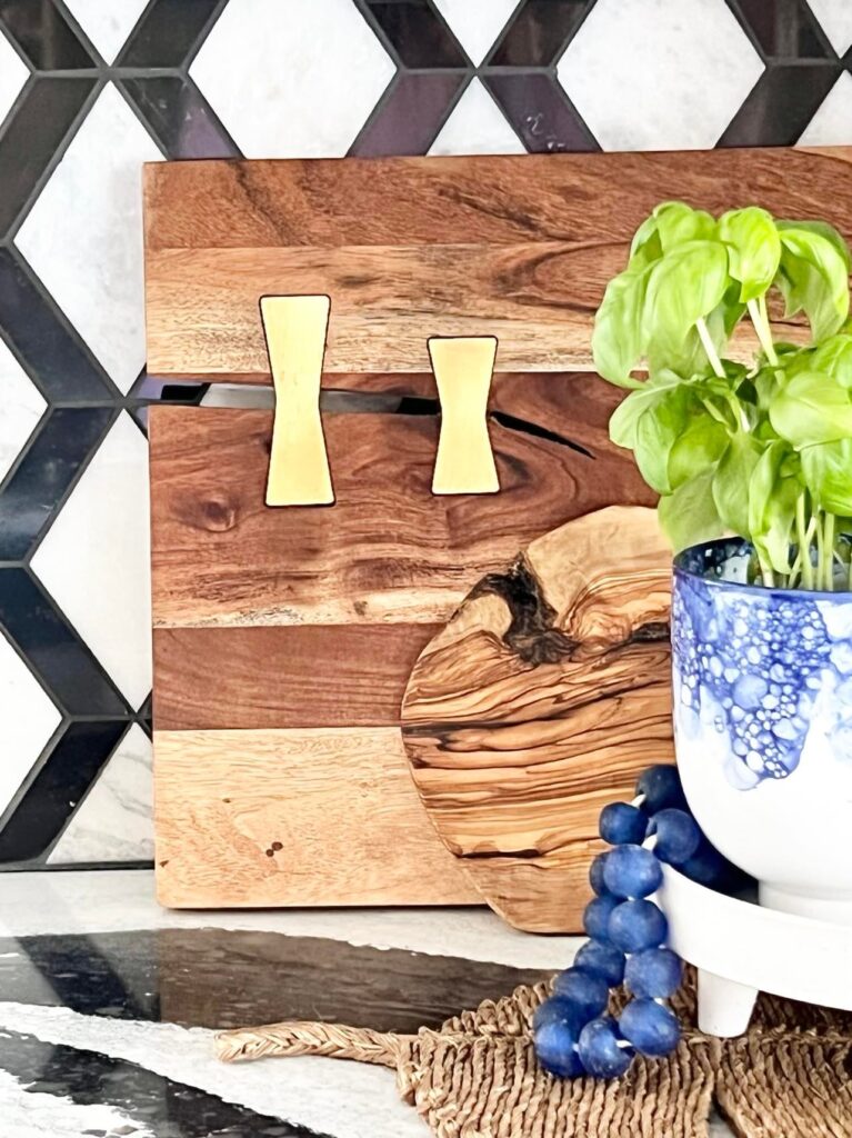 Two wood cutting boards propped decoratively against a. kitchen backsplash.