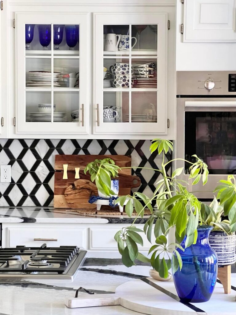 A plant cutting in a cobalt blue glass decor vase for how to decorate a kitchen island.