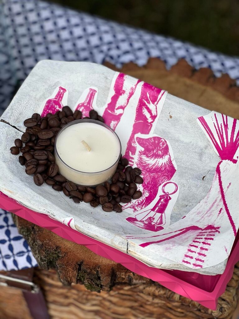 A white painted dough bowl with wallpaper cut-outs on the top.