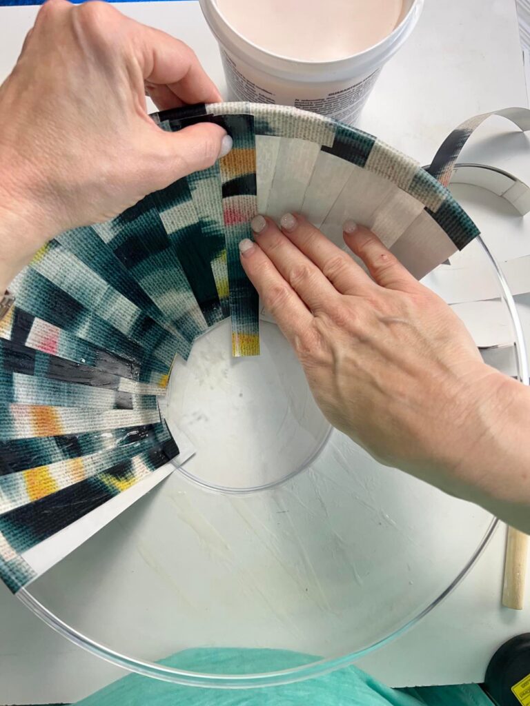 Pressing the strips of wallpaper to the inside of the DIY wallpaper bowl.