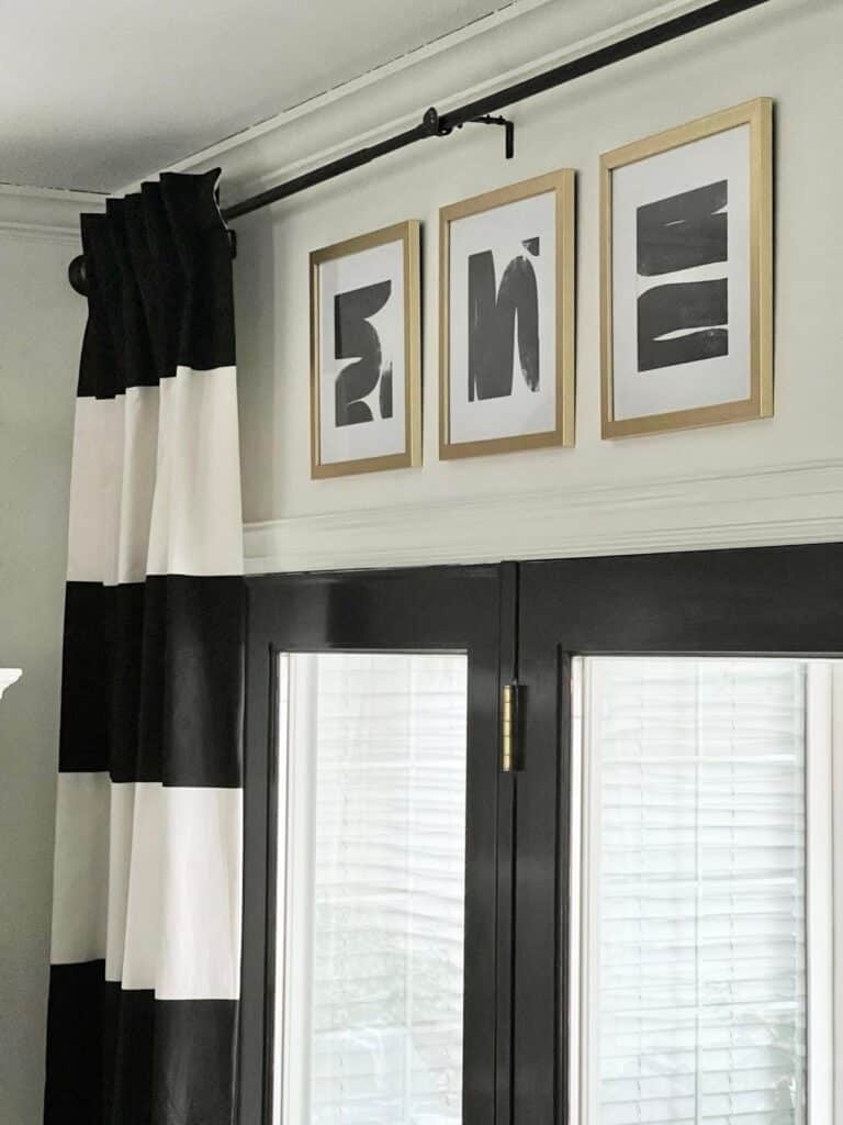 Black and white wallpaper is framed and hung above the black patio doors.