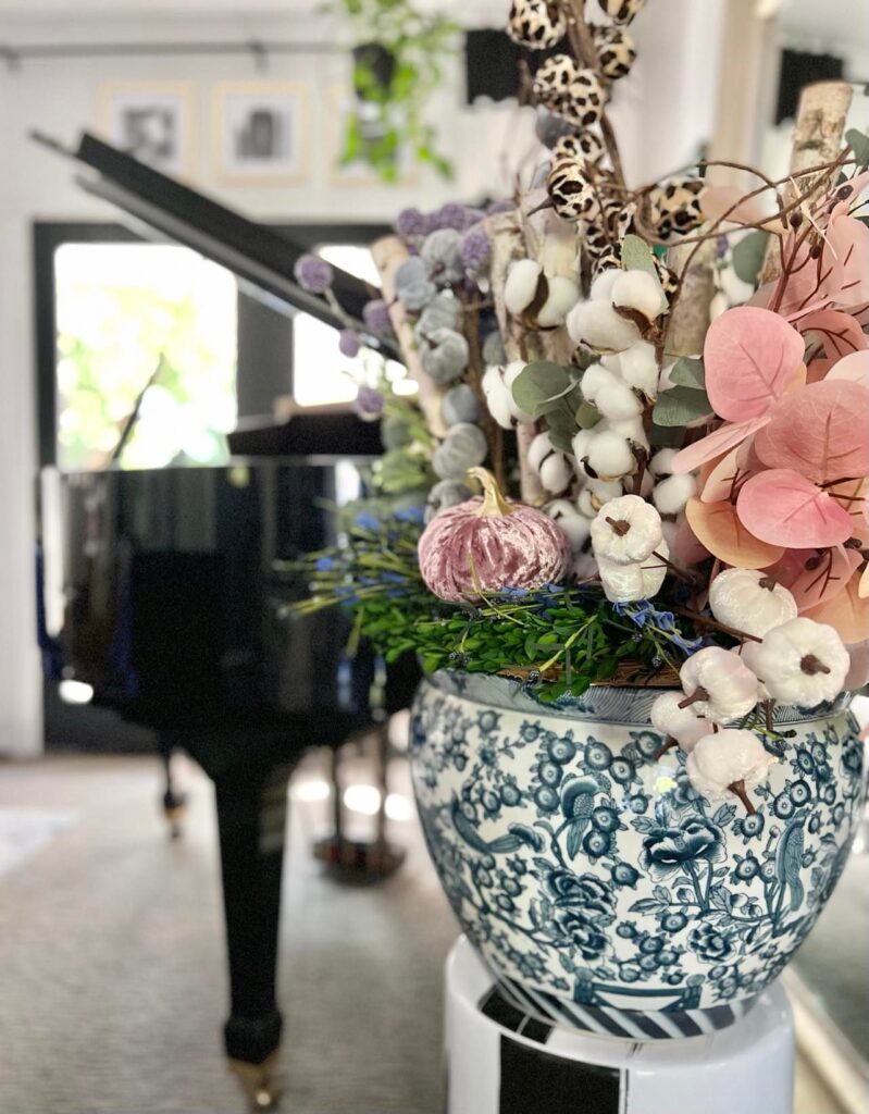 Fall florals and picks decorate a blue and white chinoiserie planter pot.