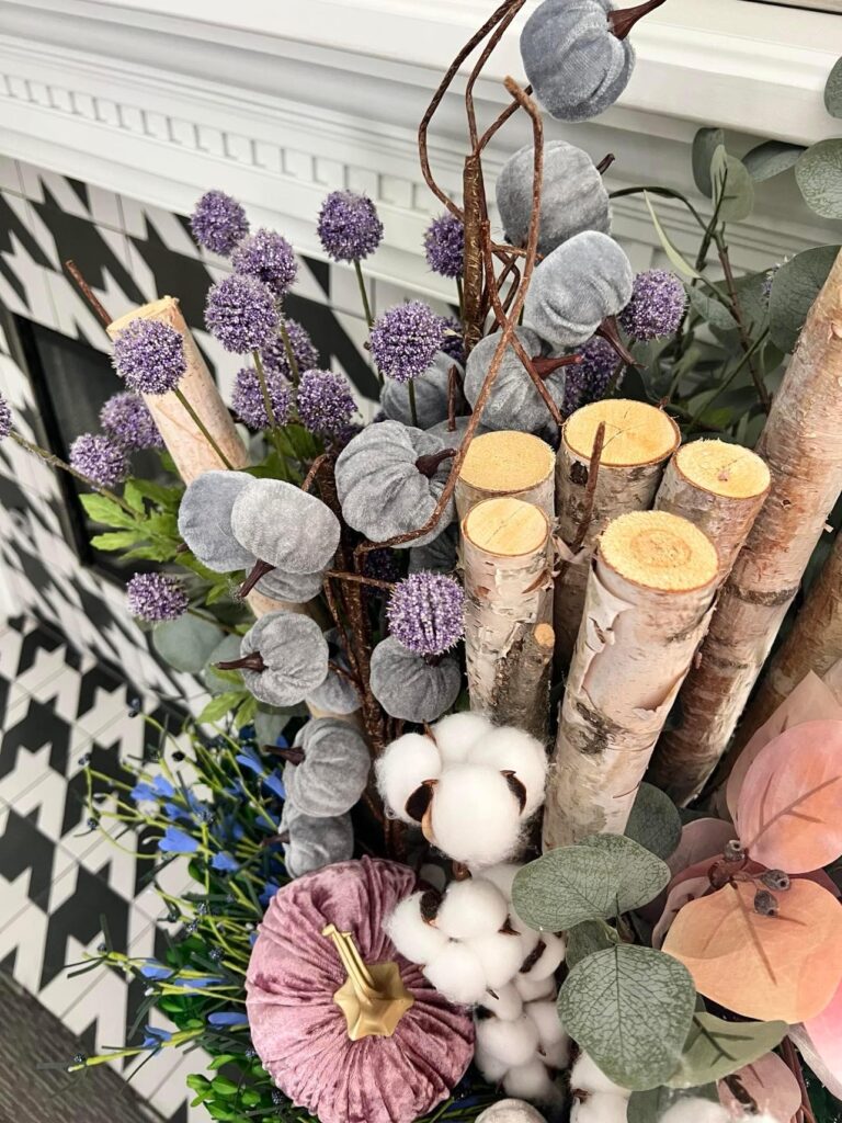 Faux fall floral arrangement sitting on a fireplace hearth.