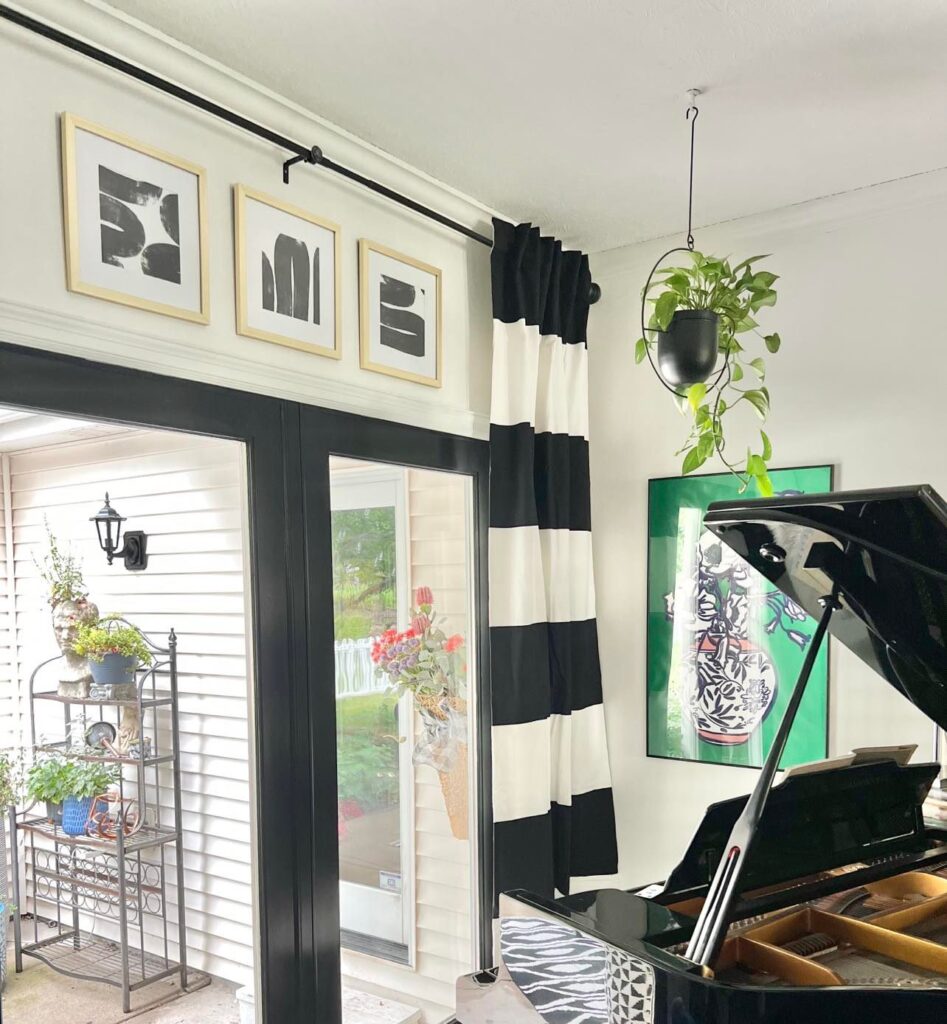 Another Living Room corner with the black and white framed wall art hanging above black doors and a glossy black baby grand piano.
