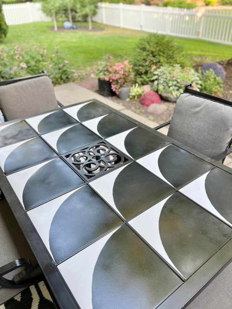 An after photo of the painted tile patio table with the makeover complete.