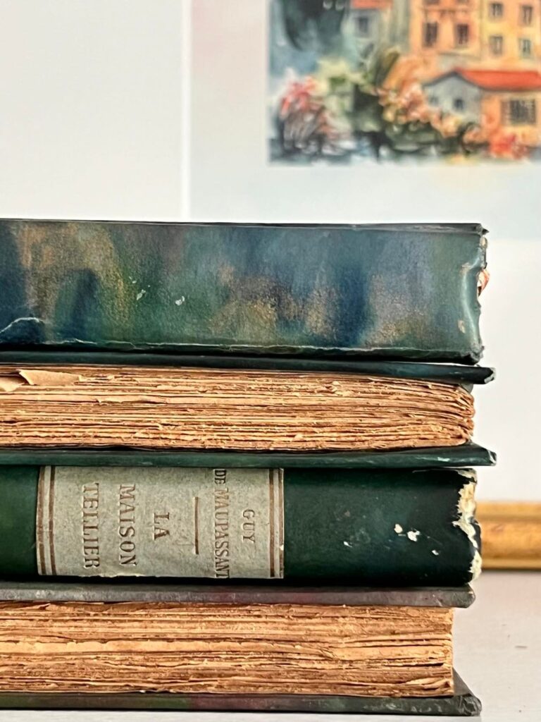 A closeup of stacked vintage books with aged pages facing outward.