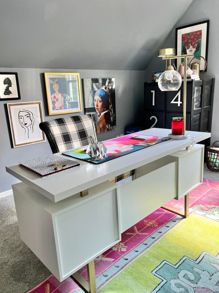 Desk styling that includes personal wall art and vibrant desk accessories.