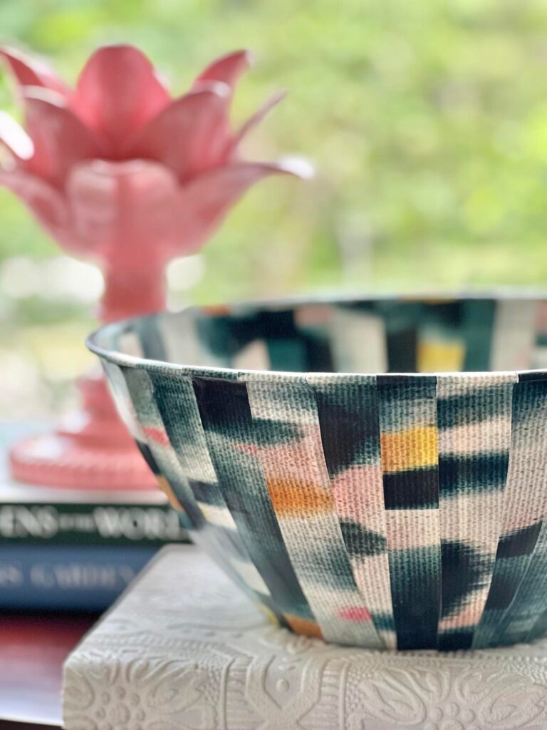 A decorative bowl created using strips of wallpaper.