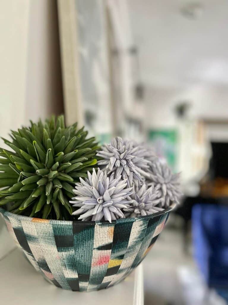 A DIY wallpaper bowl holding textured, spiky balls.