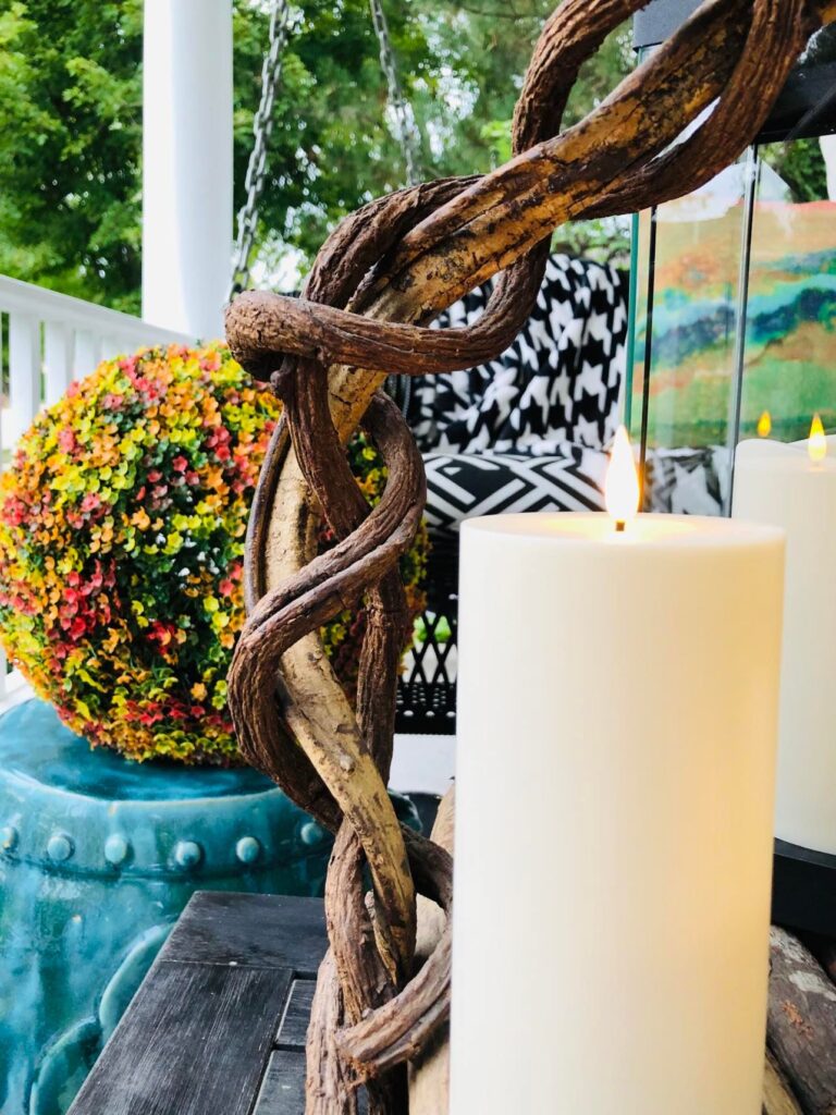 Pillar Candle on wood tray on front porch decorated for fall.