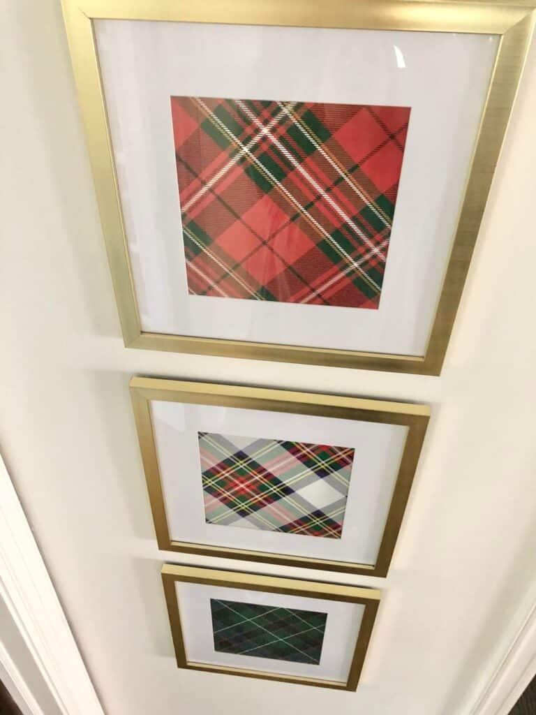 The wall frames are filled with red plaid wrapping paper for an artwork hack.