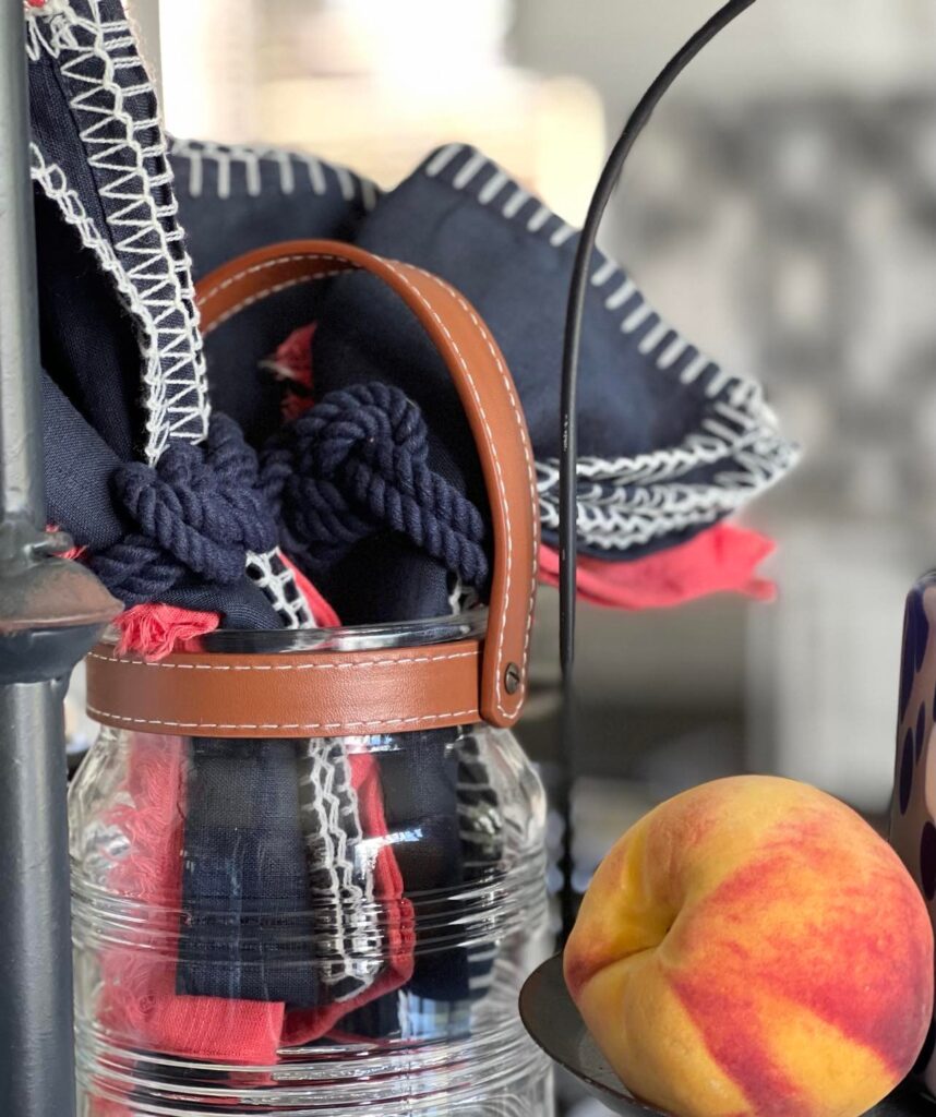 Navy and coral cloth napkins serve as fall decor in the kitchen when surrounded by fresh peaches.