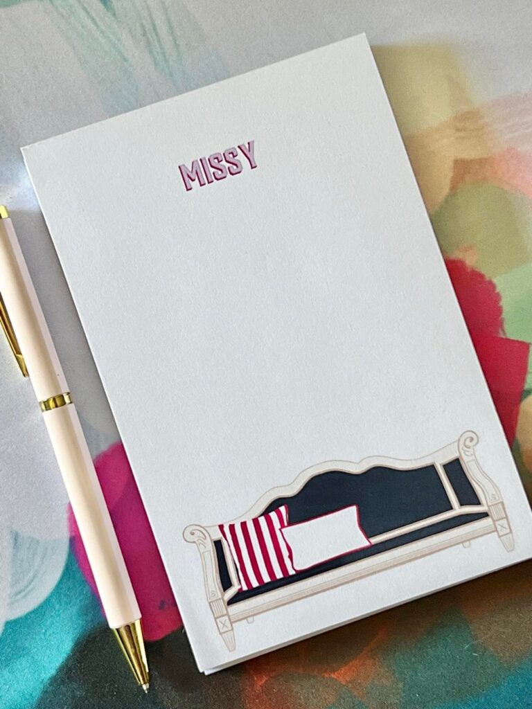 Personalized notepad and pen on a colorful desk mat.