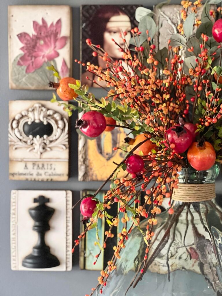 A fall kitchen centerpiece consisting of faux pomegranate stems and pip berries.