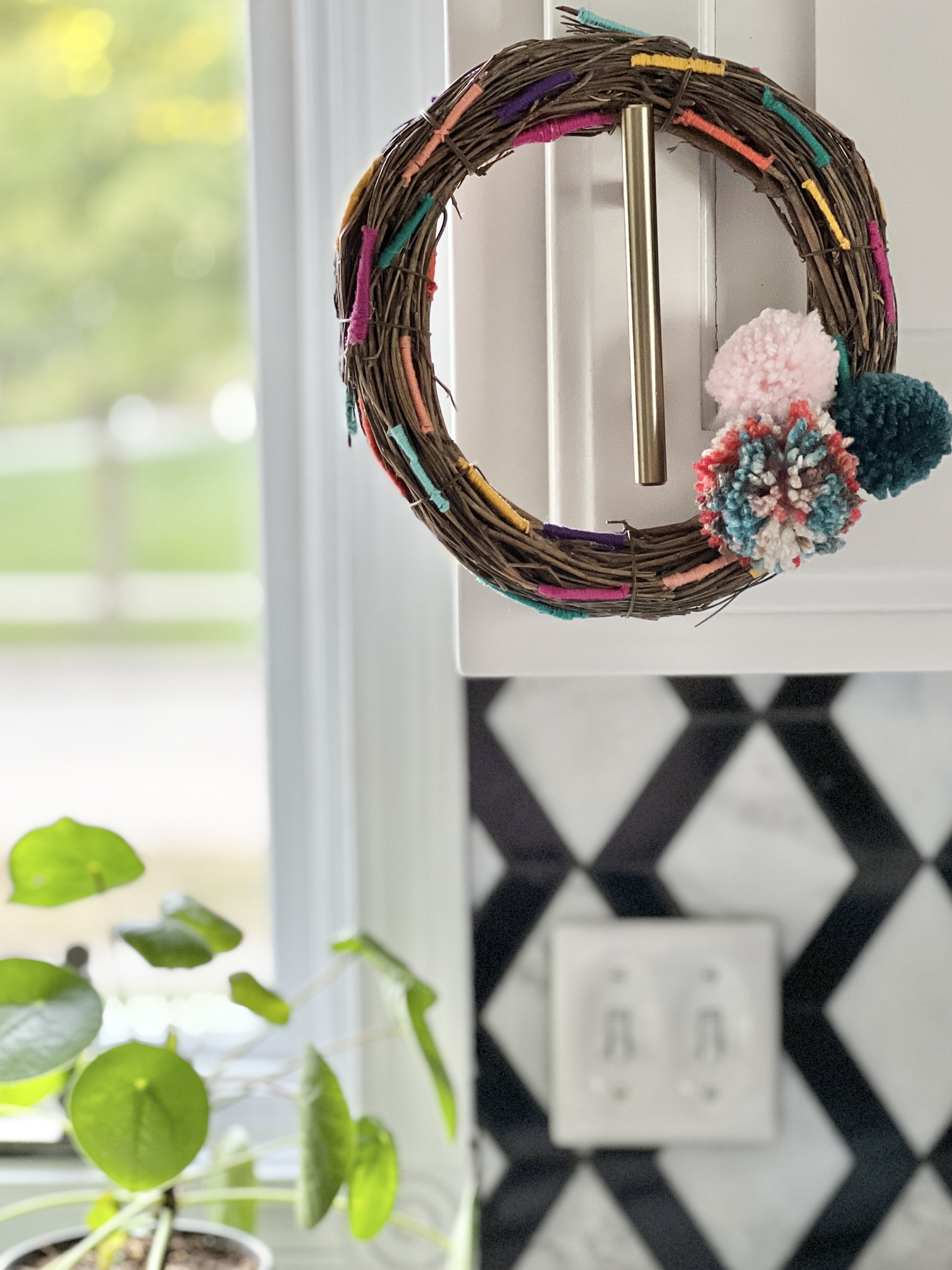 Grapevine wreath hanging from cabinet hardware.
