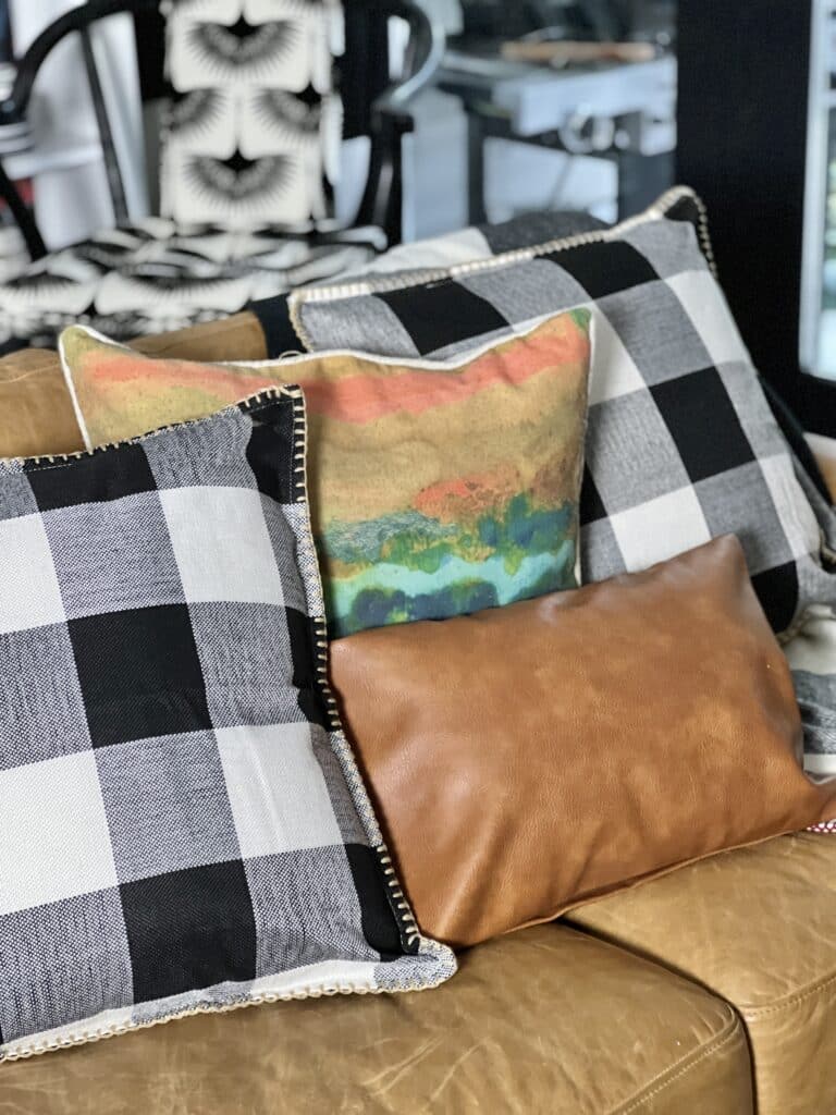 Pillows in russet, brown, and black colors for fall living room decorating ideas.