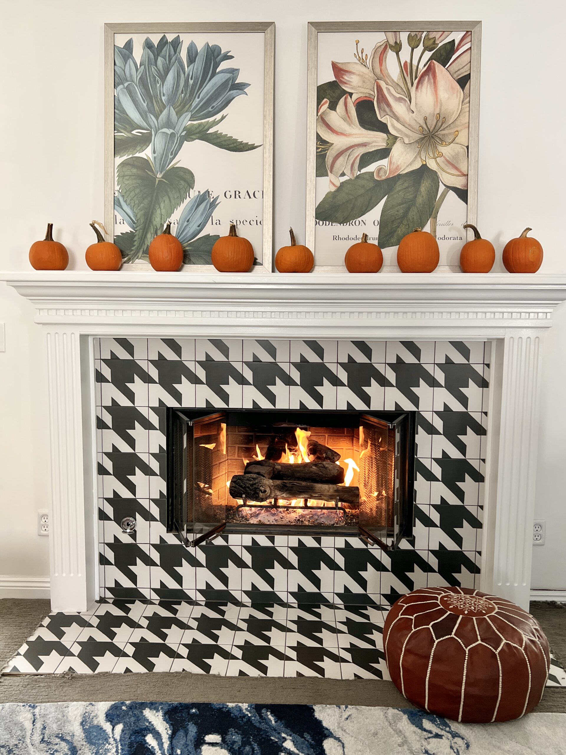 A houndstooth tiled fireplace with sugar pumpkins on the mantel.