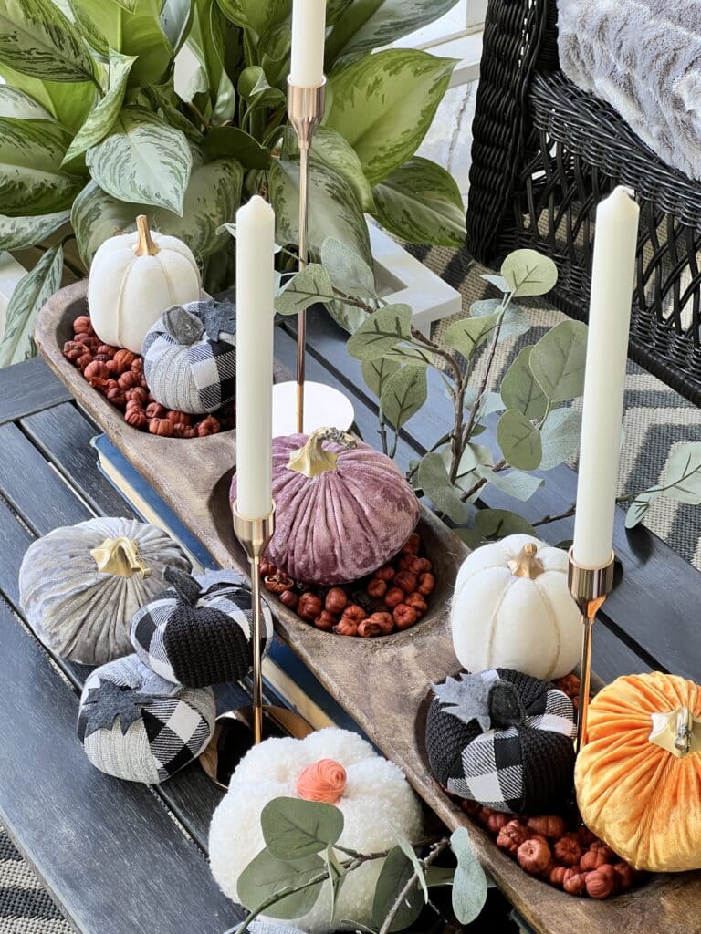 A dough bowl full of mini pumpkins and velvet pumpkins for Decorating a cozy Fall Porch Swing.