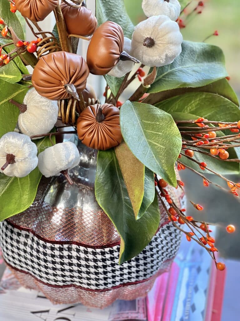 The mercury silver pumpkin vase covered with copper mesh ribbon, houndstooth ribbon, and holding faux fall florals.