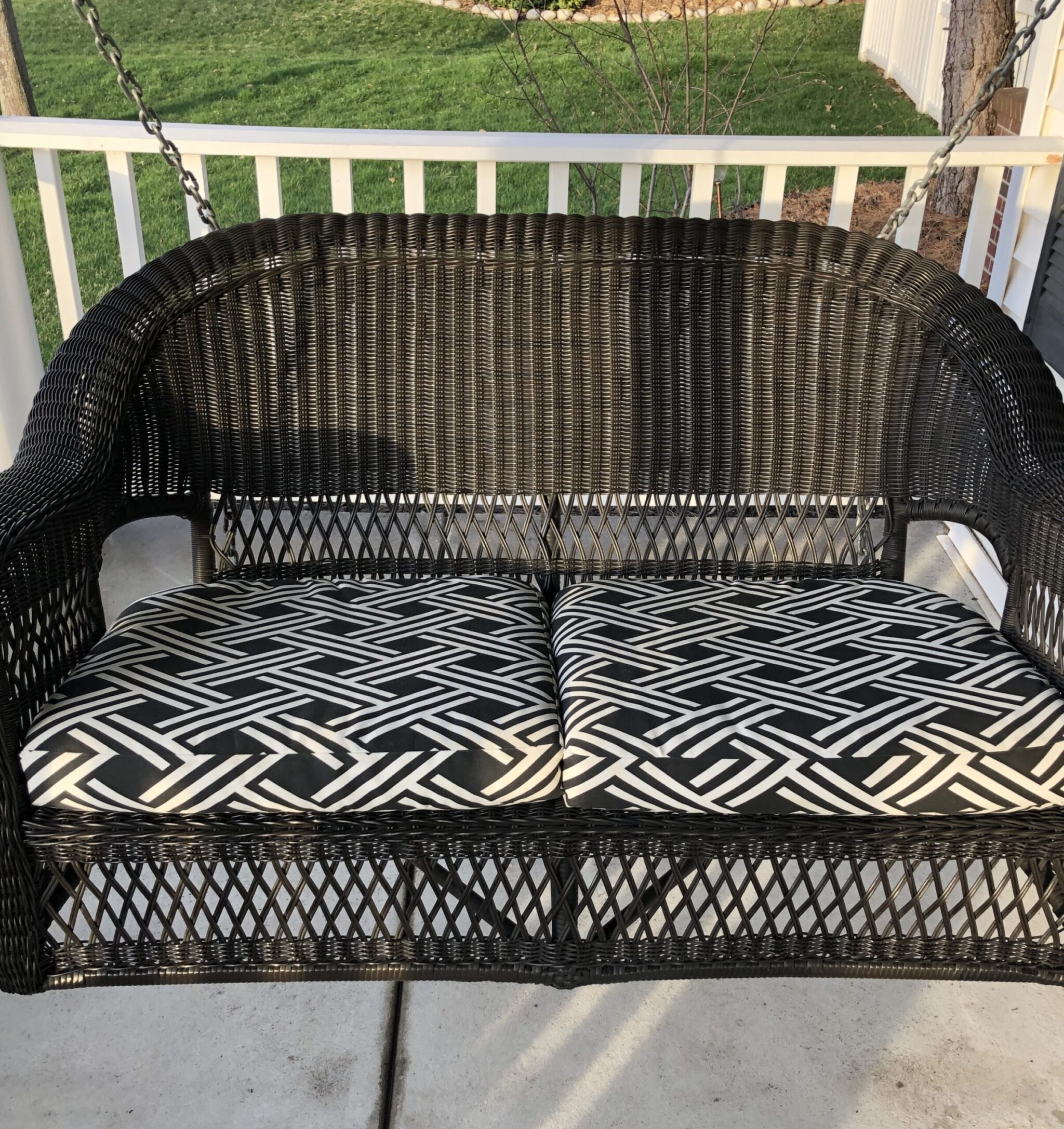 A black wicker porch swing