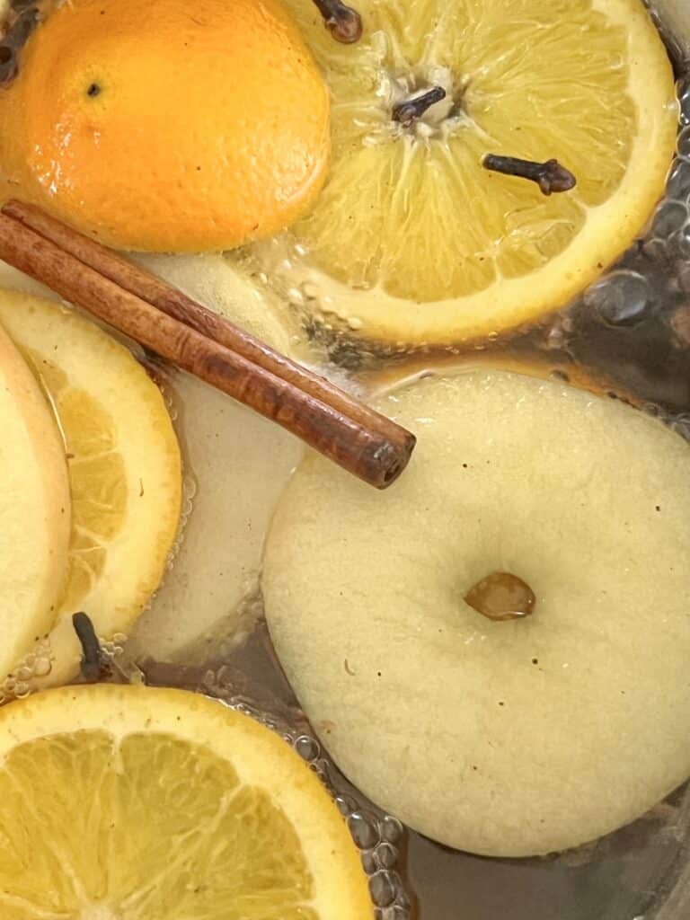 Orange and apple slices simmering in a Fall Simmer Pot on the stove.