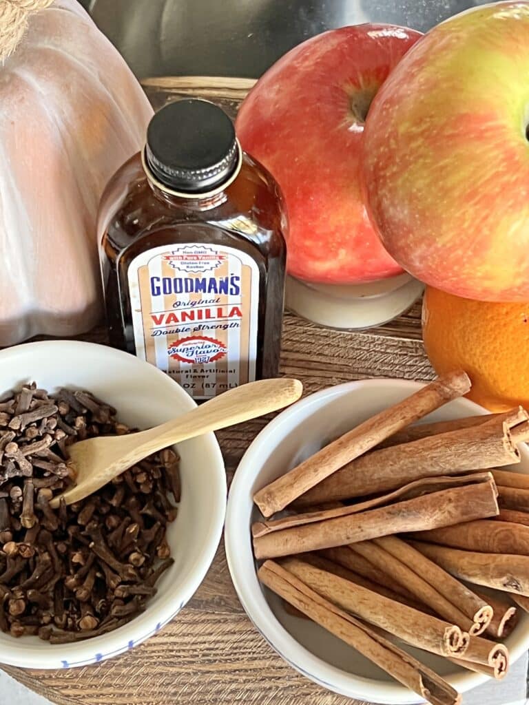 Whole cloves and cinnamon sticks in small bowls.