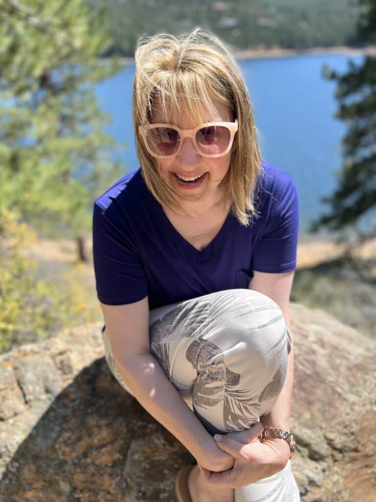 Missy sitting on a rock in the mountains.