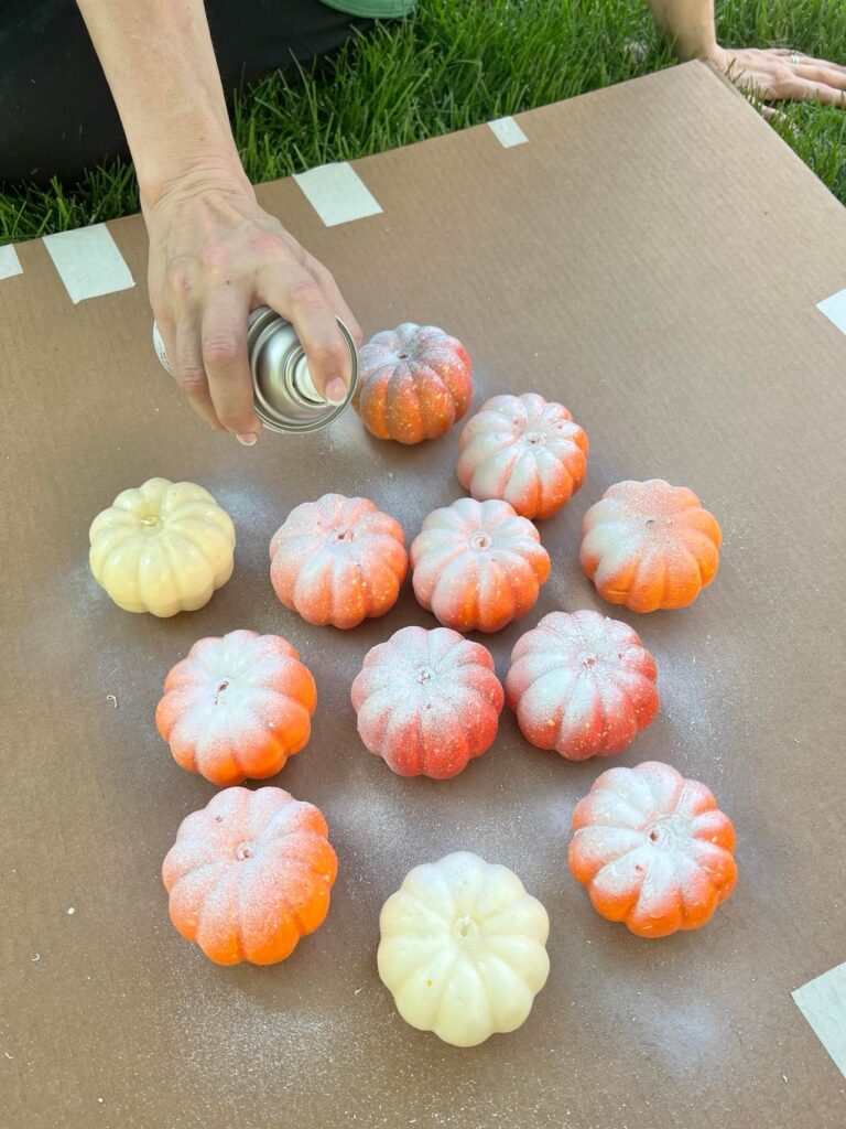 Painting the pumpkins white with spray paint
