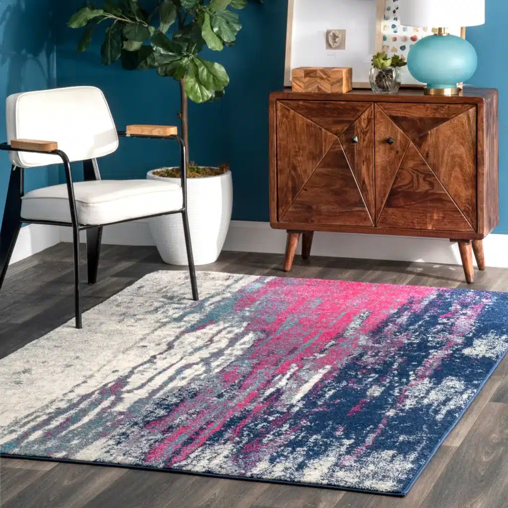 An abstract rug in blue, hot pink and ivory colors. Available from Home Depot.