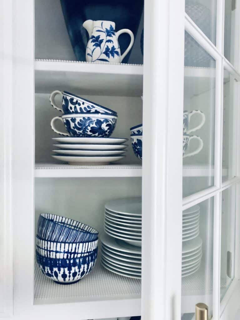 A glass kitchen door swinging open to revealed the styled shelves.