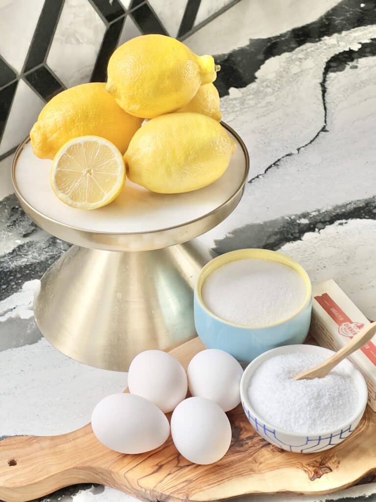 Ingredients for lemon curd including lemons, eggs, sugar, butter, and salt.