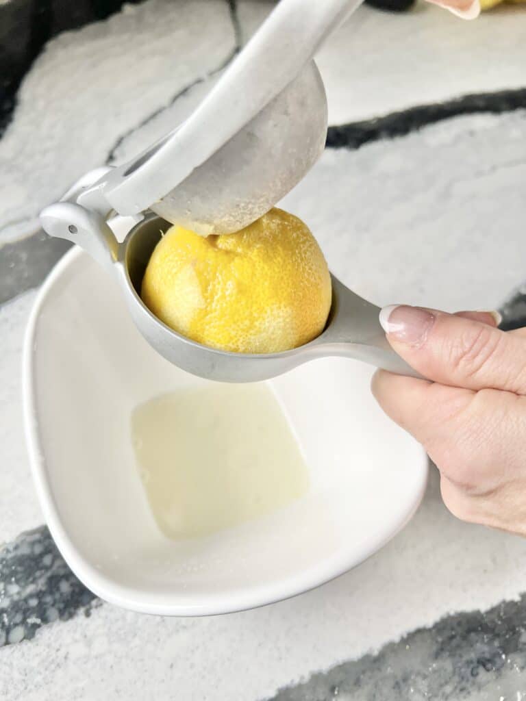 Squeezing juice from a lemon using a juicer.