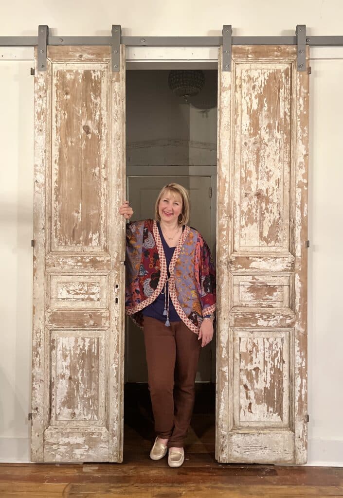 Missy standing in between wooden doors.