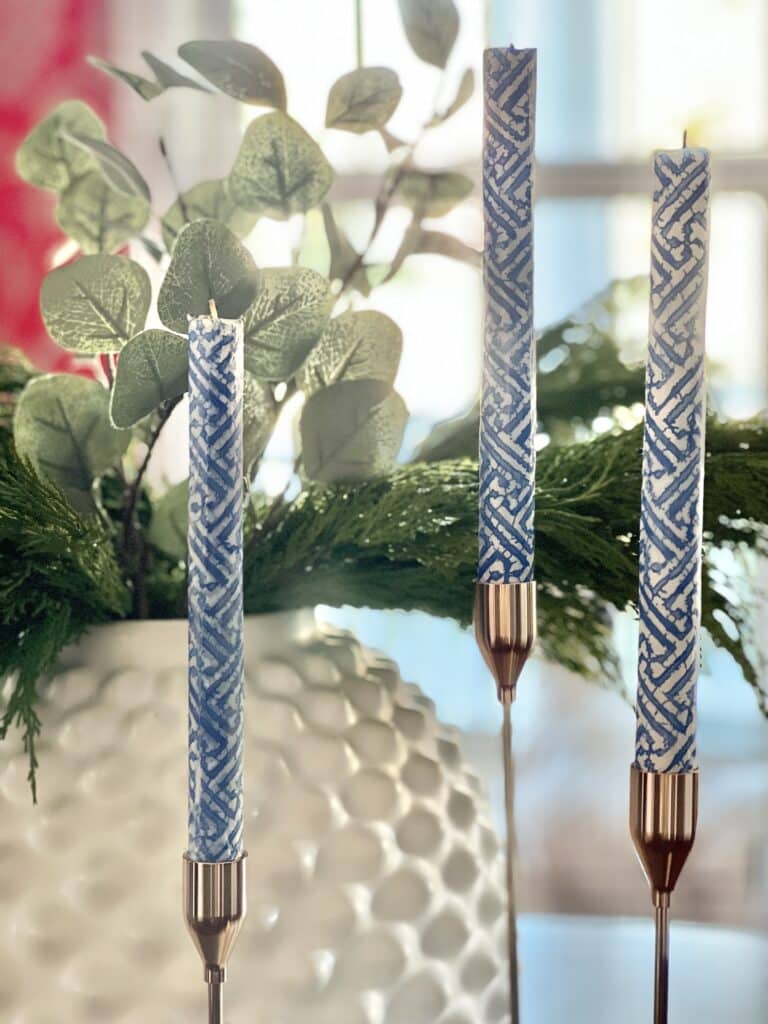 Three taper candles sitting on a dining table.