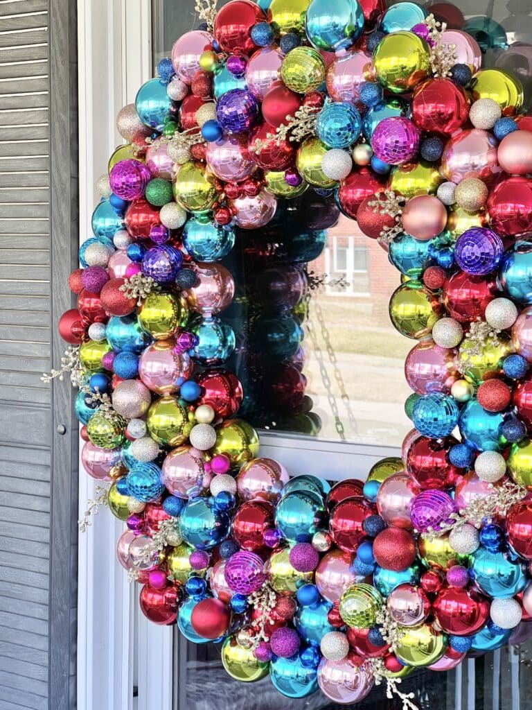 Christmas ornament wreath DIY: A pool noodle ornament wreath hung outside on a window.