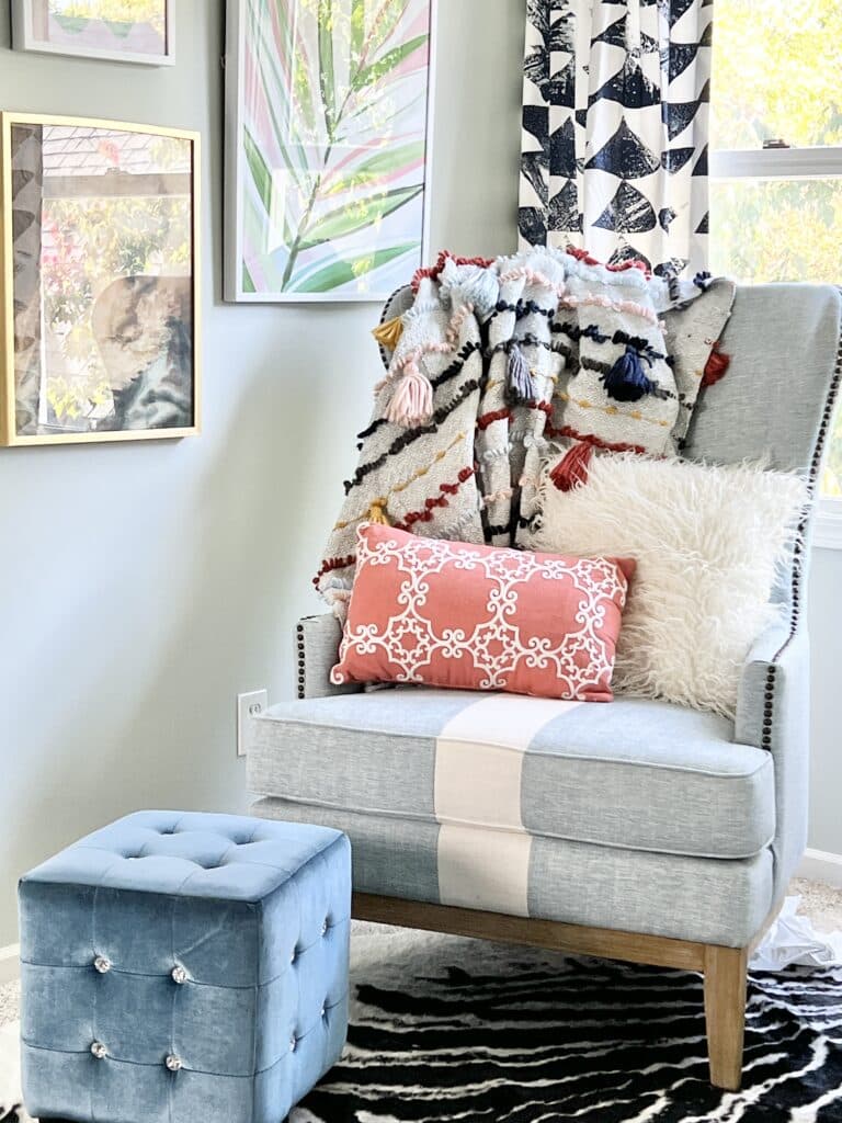 A chair with cozy pillows and throw blankets is a welcoming spot for guests to relax.