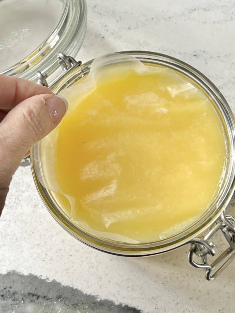 A piece of wax paper laid on top of a jar of lemon curd to prevent a "skin" from forming.